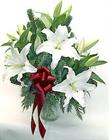 Elegant white lilies accented with holiday greens and bow make this a very discr...